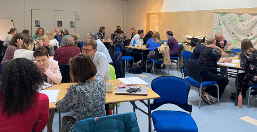 People sitting round the table having discussions at the Integrated Care at Home Board workshop